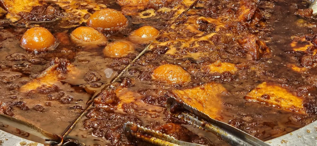 店小二滷肉飯的滷蛋、油豆腐都浸潤在跟魯肉飯一樣的滷汁裡，這樣一來滷蛋滷得入味又Q彈，而油豆腐則吸飽滷汁，一口咬下，滿嘴都是鹹香滋味。
