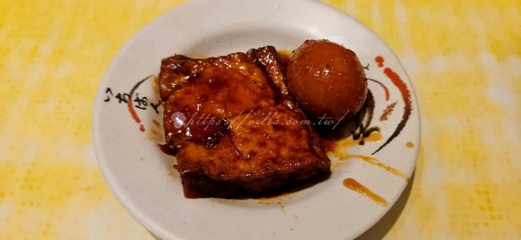 店小二滷肉飯的滷蛋、油豆腐都浸潤在跟魯肉飯一樣的滷汁裡，這樣一來滷蛋滷得入味又Q彈，而油豆腐則吸飽滷汁，一口咬下，滿嘴都是鹹香滋味。