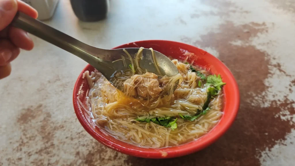 王罔的麵線糊，從視覺到味覺都與我們認知中的「麵線」大不相同。它的湯頭顏色呈現一種溫潤的米白色，清澈卻有著無比的濃稠度，麵線經過長時間熬煮後自然融化於湯中，達成真正的「糊」化狀態。