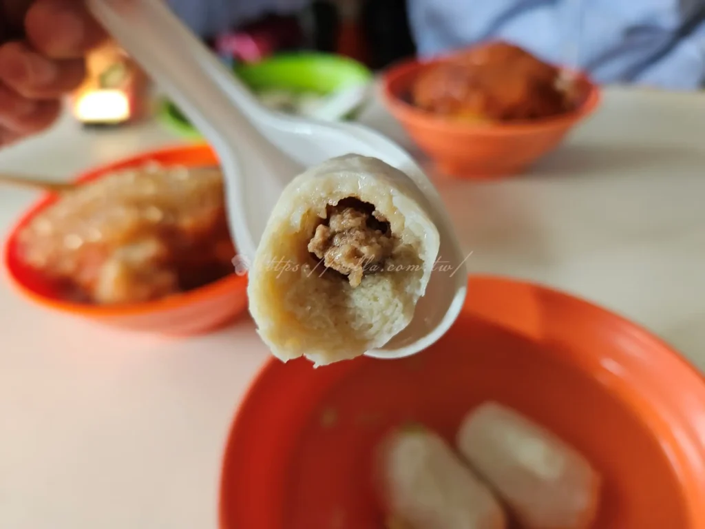 淡水文化阿給魚丸湯走的是清爽路線，魚丸彈中帶嫩，湯頭清甜，剛好平衡阿給的甜辣滋味，魚丸裡包了肉餡，一咬下去脆彈有汁，湯頭撒上一點芹菜末提味，喝起來溫潤不油膩。