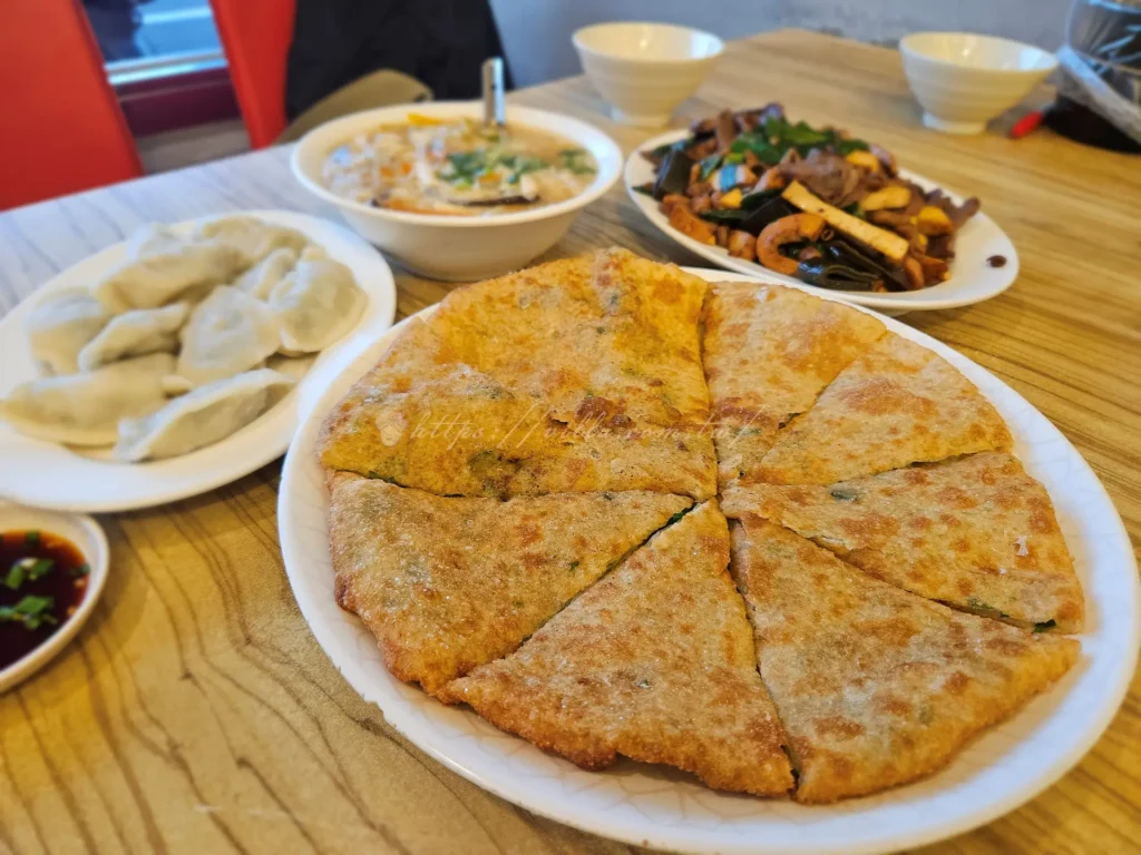 斗煥坪水餃館蔥油餅幾乎是每桌必點的招牌，也是老饕心中的鎮店之寶。口感介於傳統蔥油餅與炸蛋餅之間，外皮煎到金黃酥脆，酥香卻不乾硬，內裡保有濕潤麵香與蔥花，厚薄拿捏得恰到好處。