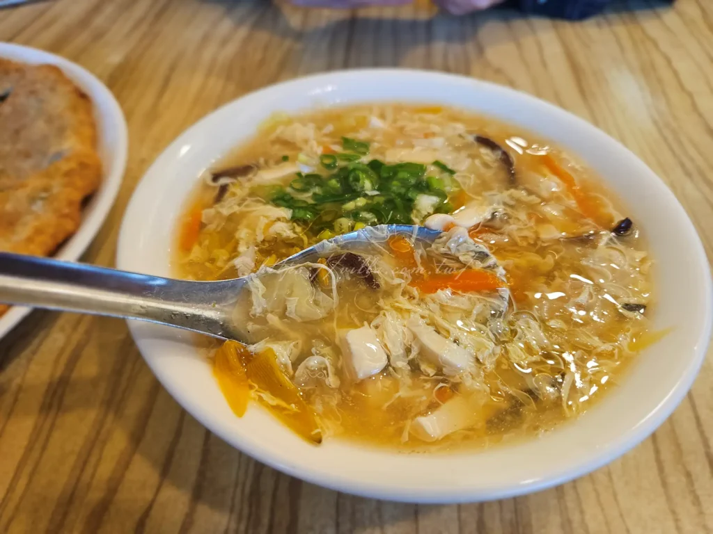 斗煥坪水餃館酸辣湯湯頭勾芡適中料豐，包括竹筍、木耳、瘦肉、蛋花與豆腐，偶有金針花增添鮮甜。辣度不強，適合大眾口味，暖胃開胃。