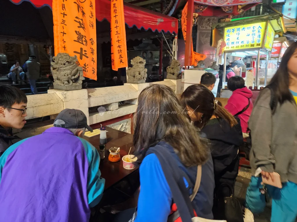 士林廟口老店阿亮麵線是讓很多台北人從小吃到大的士林老字號美食，飄香夜市超過半世紀以上，至今依舊維持那一碗樸實、勾芡濃郁的大腸蚵仔麵線風味，堪稱士林夜市必吃小吃之一。無論是本地人還是旅客，只要走過士林廟口這家麵線攤位前，都會不自覺停下腳步聞香而來。