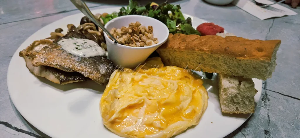 布納咖啡館(BUNA CAF’E)塔塔烤鱸魚這是一道令人驚艷的健康之選。鱸魚皮烤得微焦酥脆,魚肉則保持著細緻鮮甜的肉質。