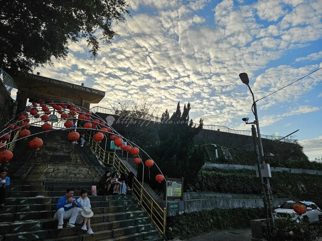 位於老街最高處的九份國小，是遠離塵囂的祕境景點，這裡擁有全山城最遼闊的視野，能將基隆山與深澳灣的海景盡收眼底，校門口前的長階梯更是熱門拍照點，許多遊客買完阿柑姨芋圓後，會坐在這靜靜享受海風，是感受九份靜謐氛圍的最佳去處。