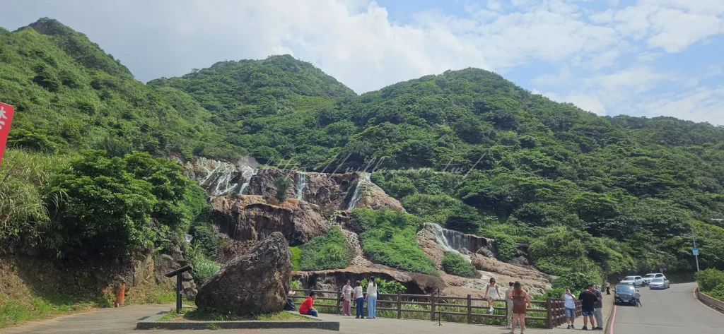 除了老街核心區，周邊的自然奇景也是九份景點的重頭戲。沿著公路下山，你會看到如畫般的黃金瀑布，那因礦物質沉積而呈現的金黃色岩石，搭配湍急水流非常震撼，接著往下走，著名的陰陽海以湛藍與鵝黃交織的海水奇景聞名。