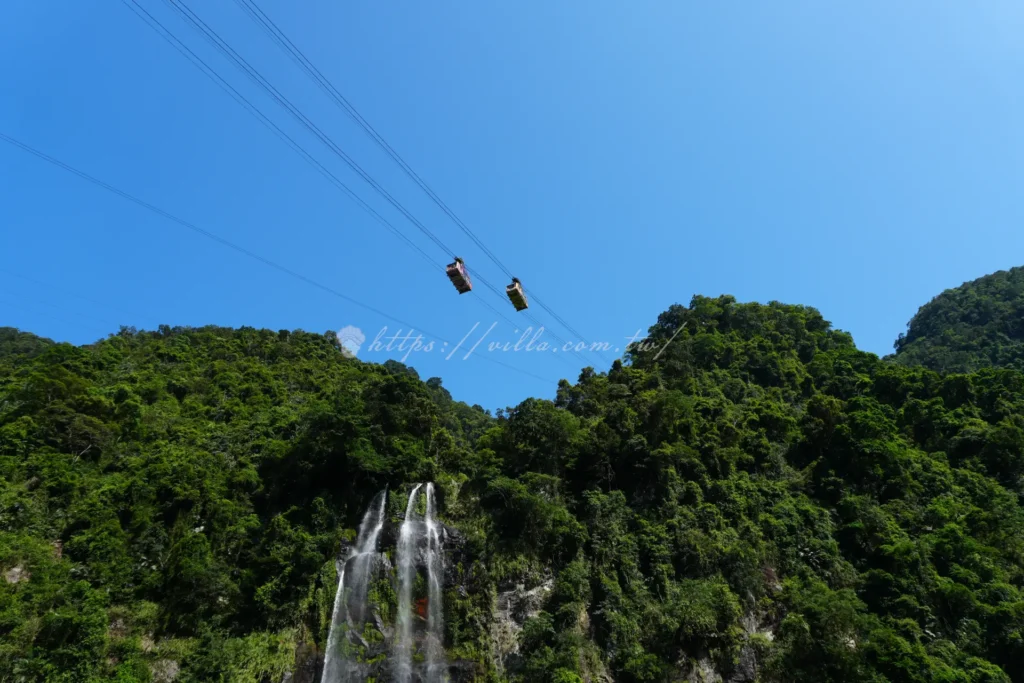 烏來瀑布與纜車同框畫面，壯觀水瀑傾瀉而下與空中纜車交織成烏來最具代表性的經典景色