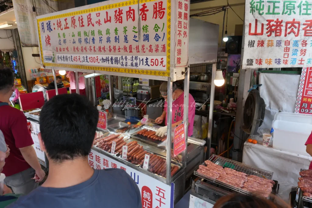 烏來老街現烤山豬肉香腸，炭火烤得外皮焦香油亮，是泰雅族原住民風味必吃小吃