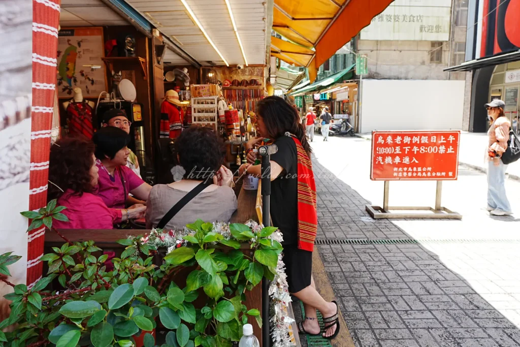 身穿泰雅族傳統服飾的女性，色彩鮮豔的原住民織布紋樣展現部落工藝之美