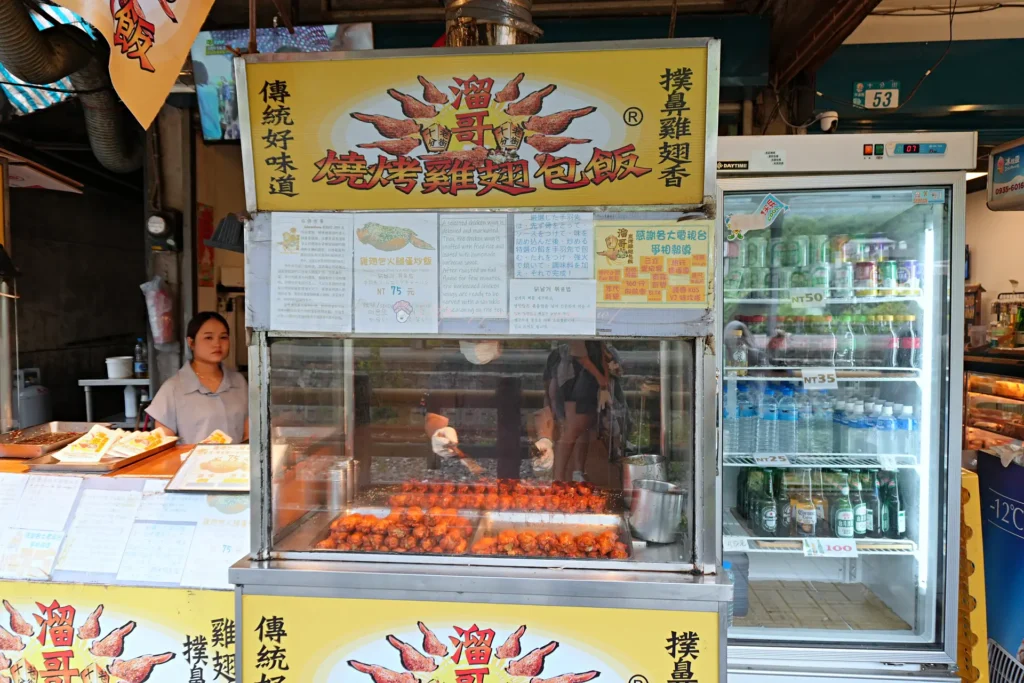 十分溜哥燒烤雞翅包飯老街人氣最高的單品,韓國旅客特別愛。雞翅去骨後塞入火腿蛋炒飯,炭烤刷醬,一口咬下先是焦香雞皮,再是軟糯炒飯,層次算到位。