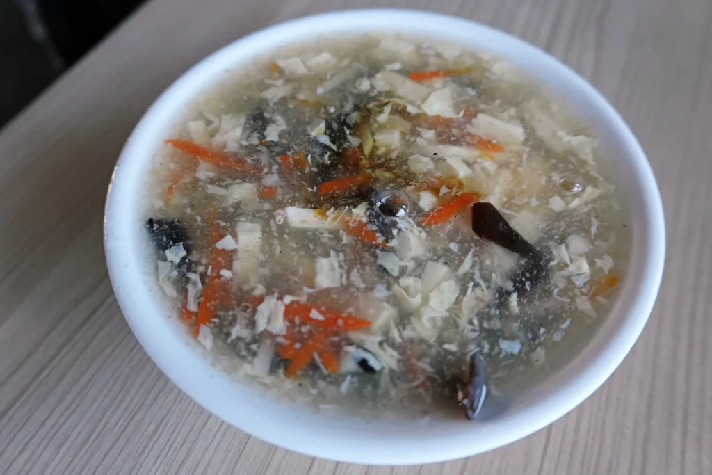 正好鮮肉小籠包酸辣湯濃稠掛勺,豆腐絲蛋花配料特寫