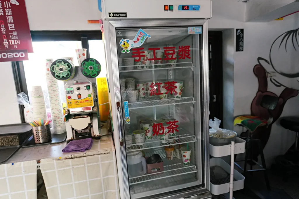 正好鮮肉小籠包五結店酸辣湯供應櫃檯,旁邊擺放豆漿紅茶奶茶飲料冰箱