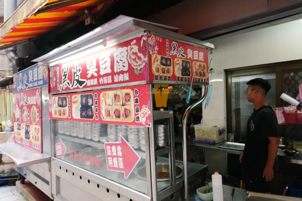 黑皮臭豆腐-排隊老店,門口攤車的三色臭豆腐有紅麴、竹炭、傳統三色,中間挖洞吸醬、外皮酥脆,紅麴味最突出。