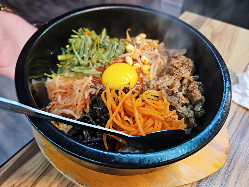 海雲韓式料理石鍋拌飯，中央擺上生蛋黃與多樣配料