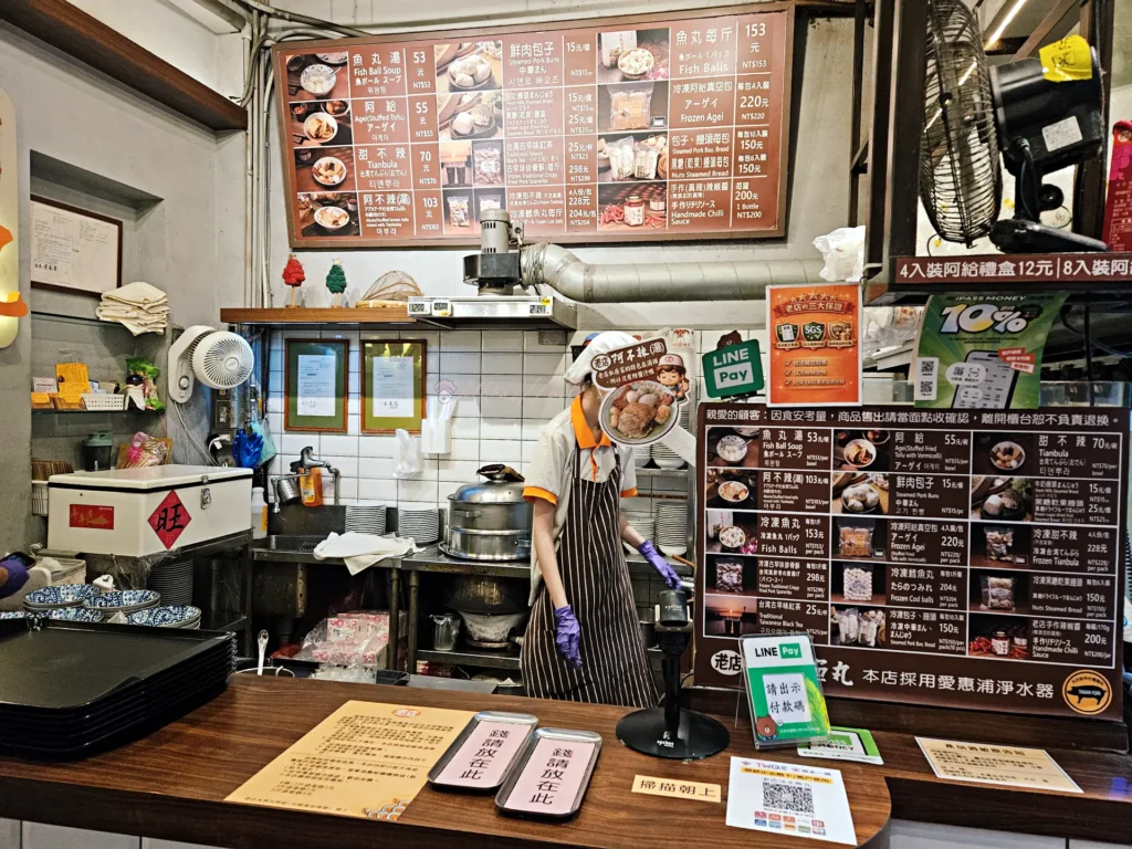 老店淡水魚丸阿給內部工作區,師傅現場處理食材畫面