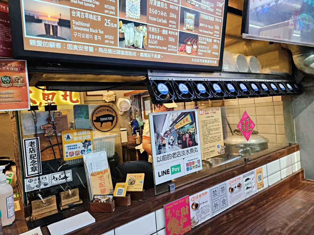 老店淡水魚丸阿給吧台座位區與牆面菜單展示