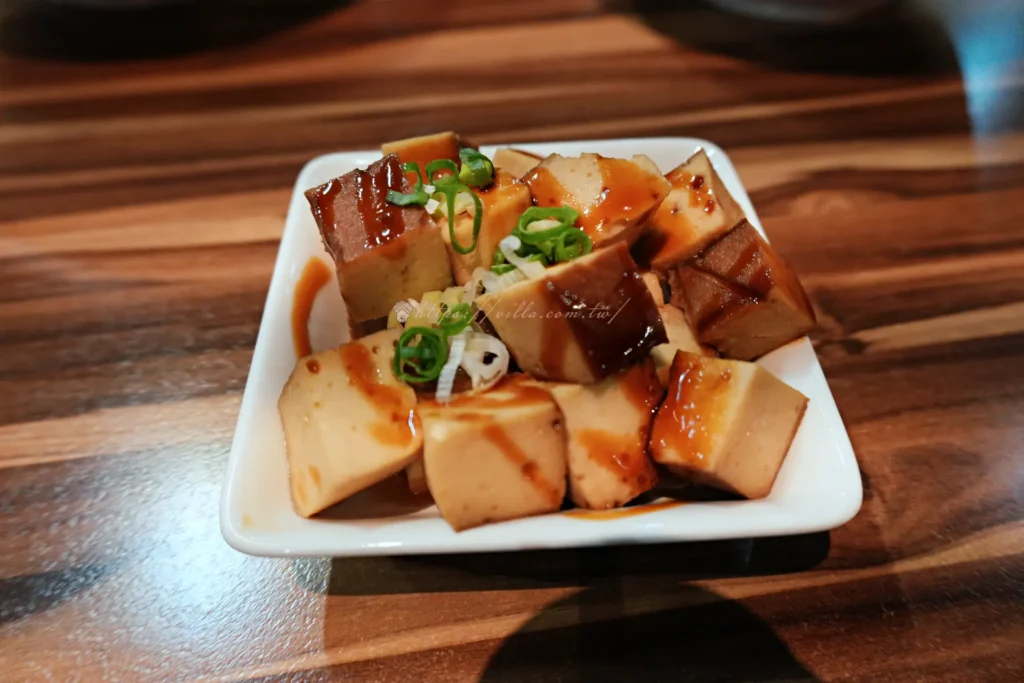 牛麵豆干小菜，切成三角塊，撒上蔥花與辣椒