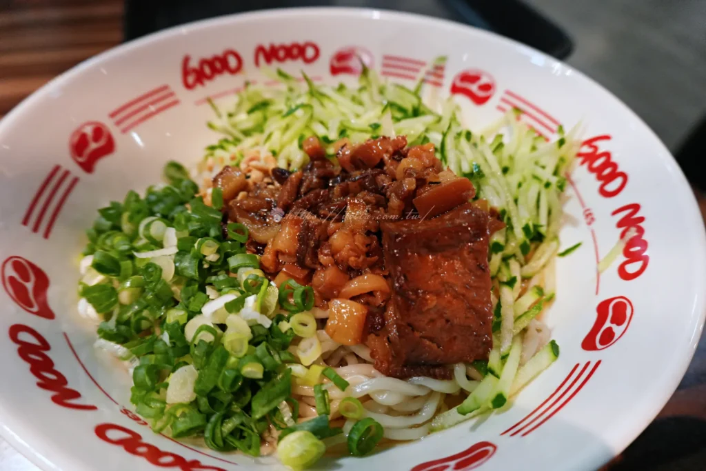 牛麵乾拌牛肉麵，細麵上鋪滿蔥花、小黃瓜絲與燉牛肉塊