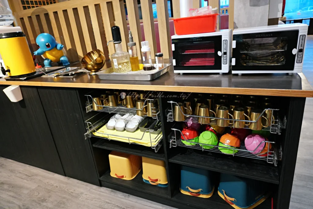 牛麵自助台，擺放餐具、醬料與飲水