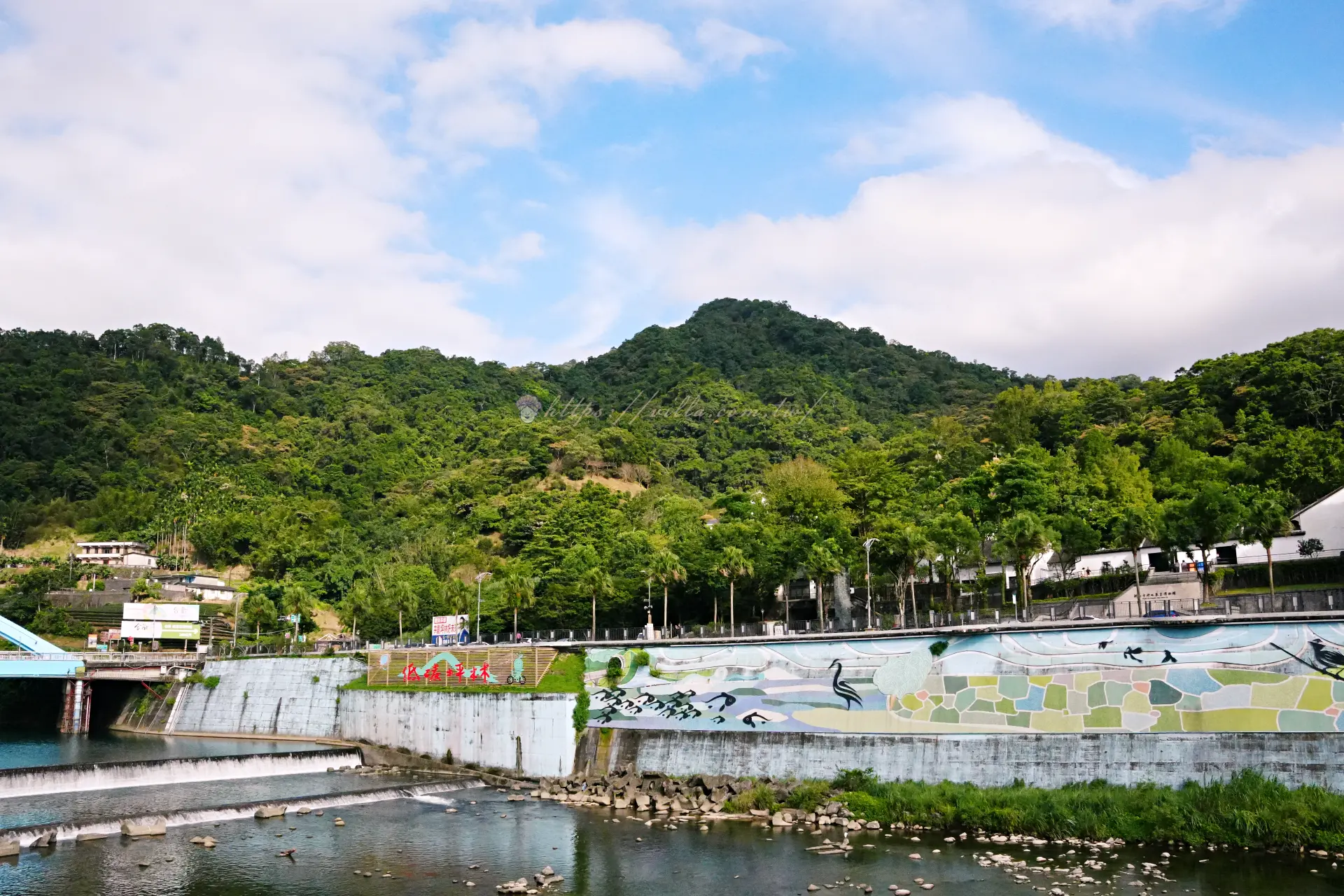坪林北勢溪岸彩繪堤防與遠方綠色山稜線